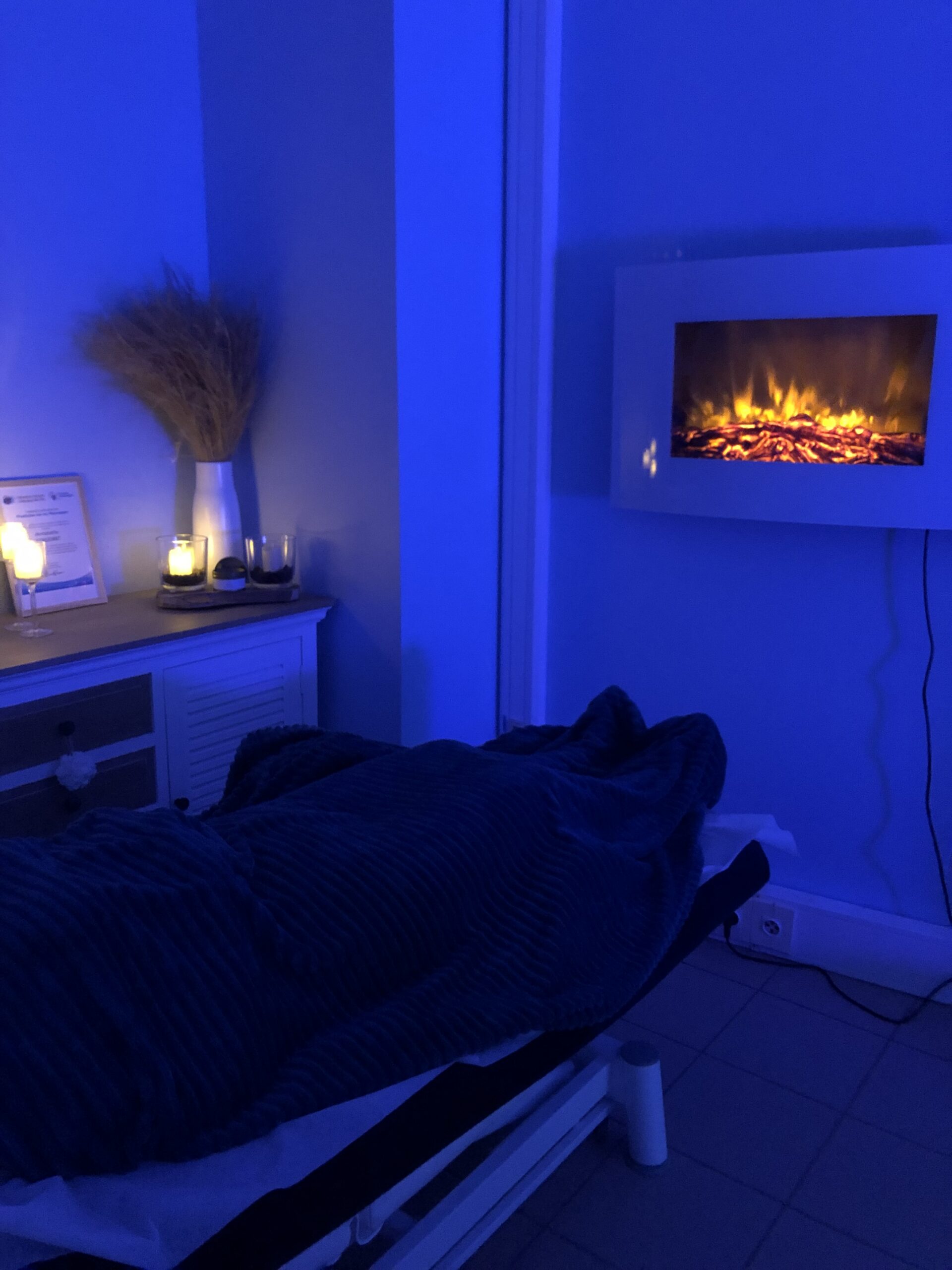 cliente recevant un soin de bien-être devant la cheminée dans le bureau D du pole santé denis lambin de montreuil sur mer